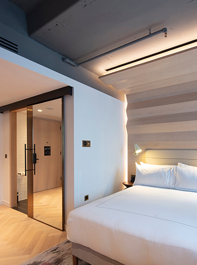 London Hotel Hospitality Guestroom Integrated Canopy Layered Light Illuminating Warm Interior Lighting Designers Nulty
