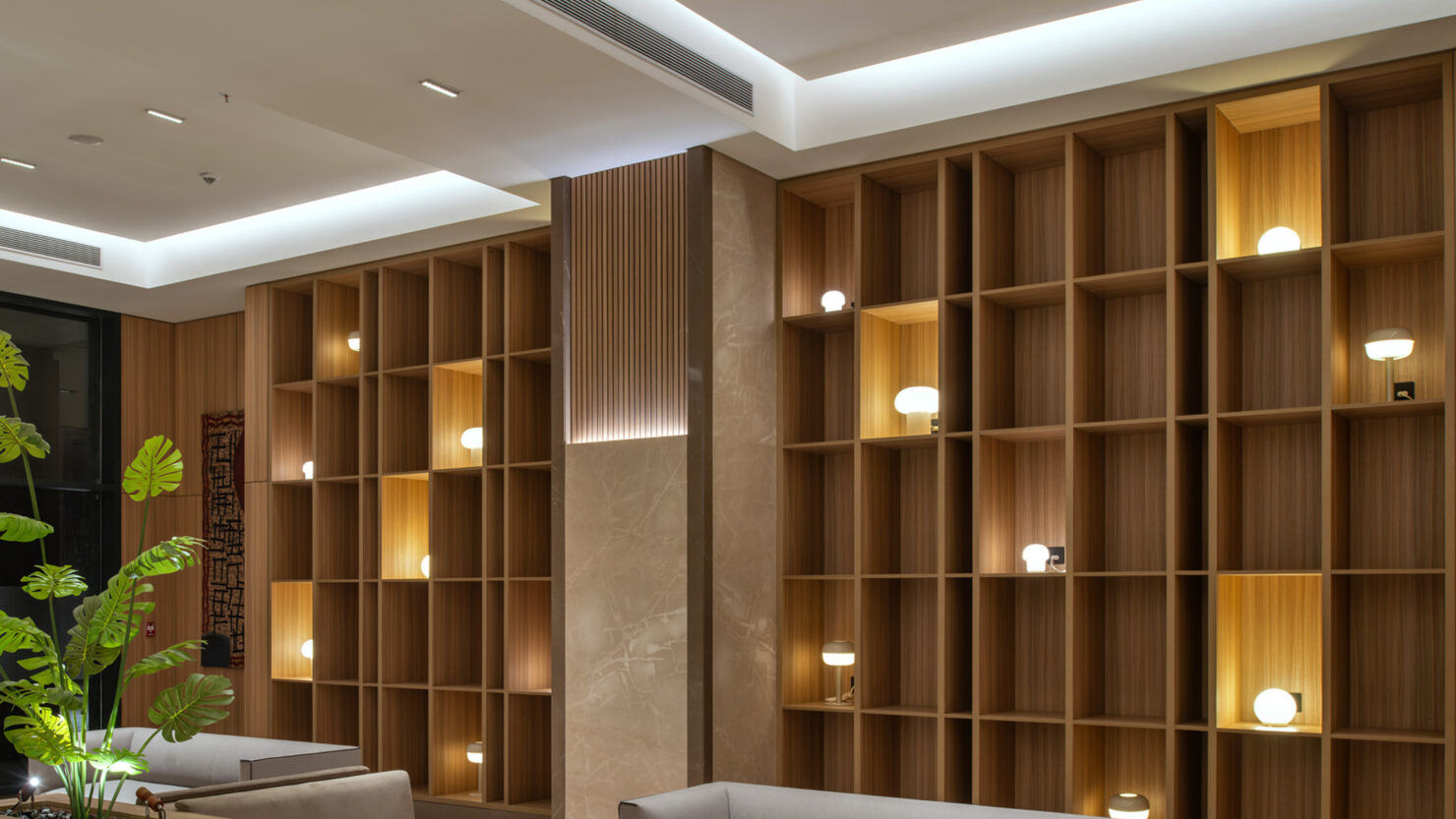 Pachshil avenue lobby : Shelving is animated with a blend of integrated lighting and decorative luminaires, composed in-house by Nulty. 